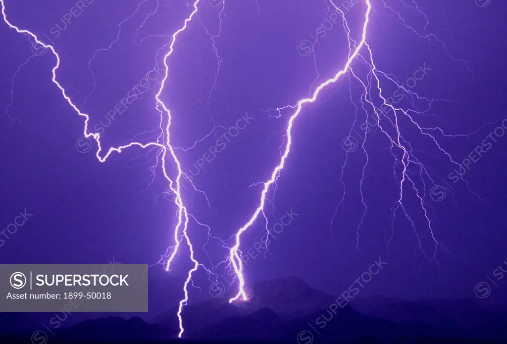 Dramatic cloud-to-ground lightning flashes with four strike points in the Tortolita Mountains.  Southern Arizona, USA.