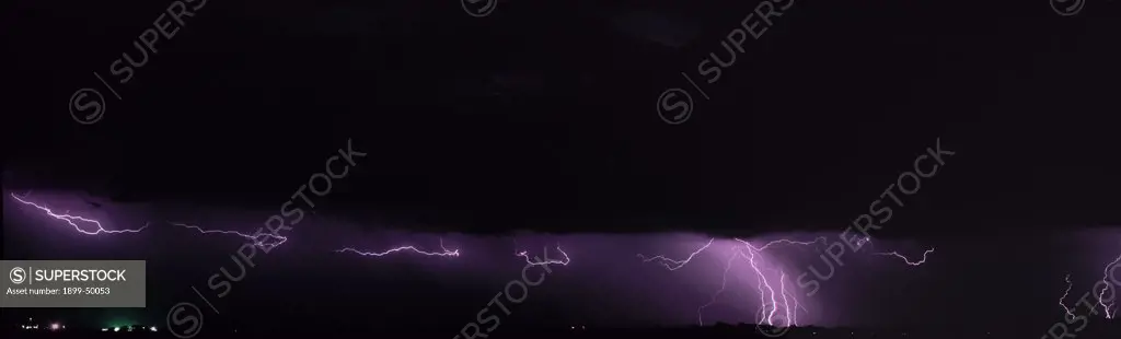Two types of lightning from base of a storm cloud northeast of Tucson, a series of lightning crawlers under the cloud base and cloud-to-ground discharges. Summer monsoon season, Sonoran Desert. Southeastern Arizona, USA. Panoramic 6x17 film