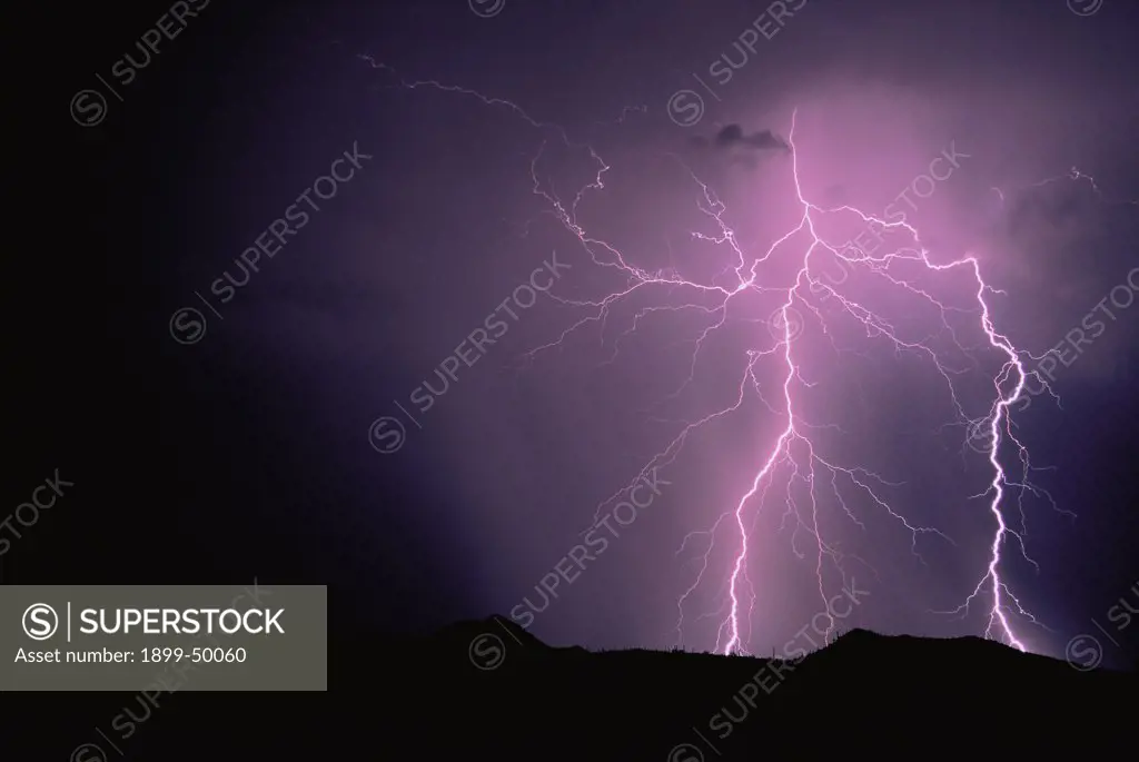 Two cloud-to-ground lightning strikes illuminating rain shaft.   Tucson Mountains, Tucson, Arizona, USA.