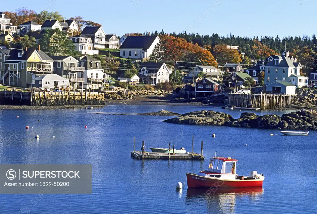 Stonington Harbor, a typical New England fishing village, with a lobster boat in the foreground (October 1996). Coastal Maine, USA.