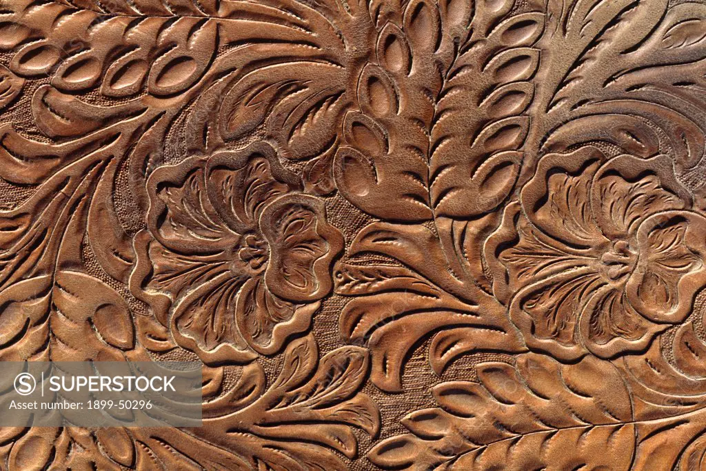 Ornate floral and leaf tooled leather detail on a western saddle. Photographed at the Institute of the Range and the American Mustang (IRAM) Wild Horse Sanctuary. Black Hills, Meade County, South Dakota, USA. -either horizontal or vertical