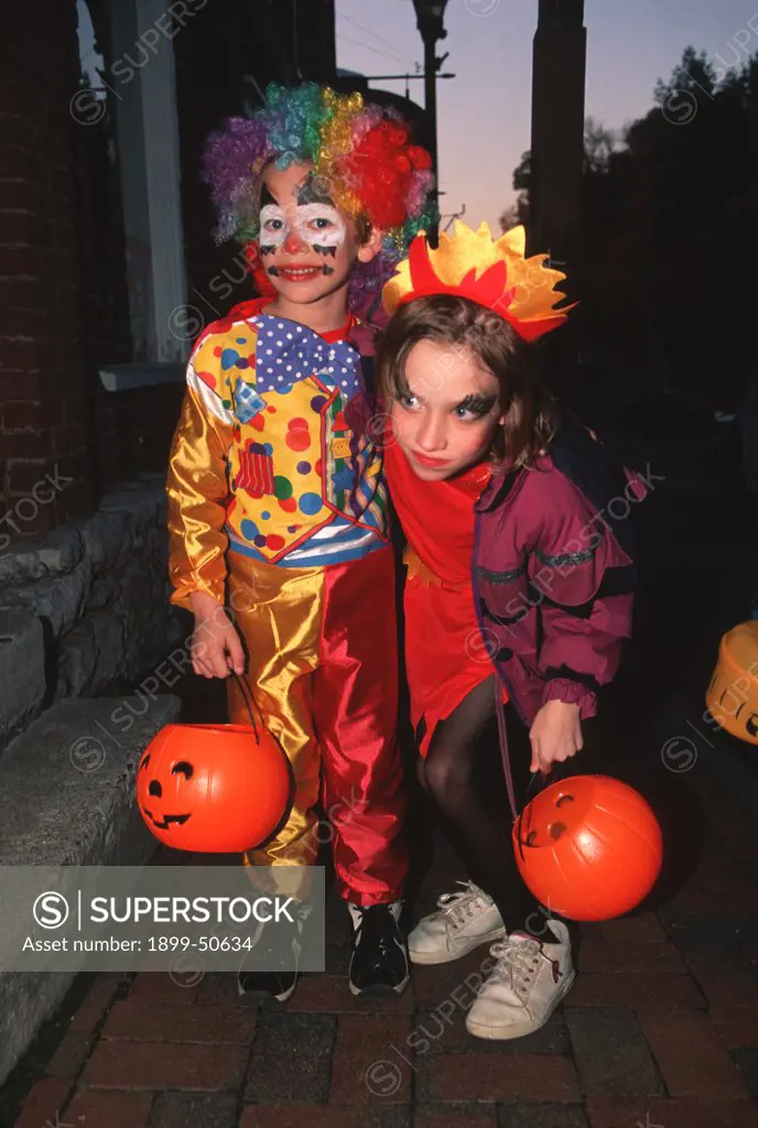 Two Girls Trick Or Treating On Halloween, Holding Plastic Pumpkin Buckets