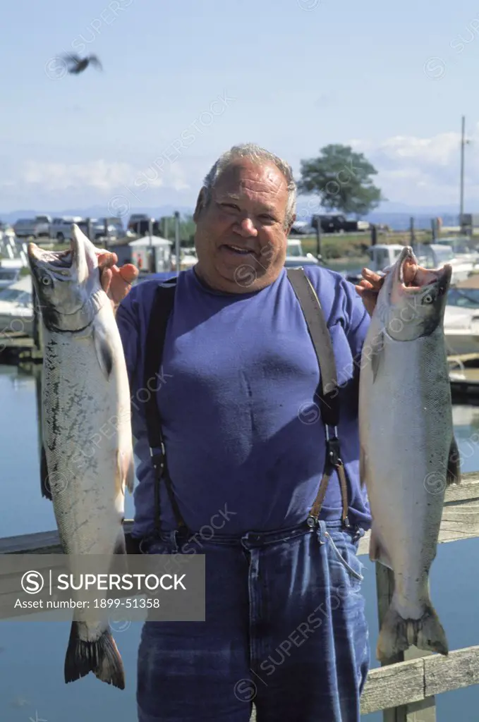Washington, Chinook. Fisherman With Silver Salmon Catch