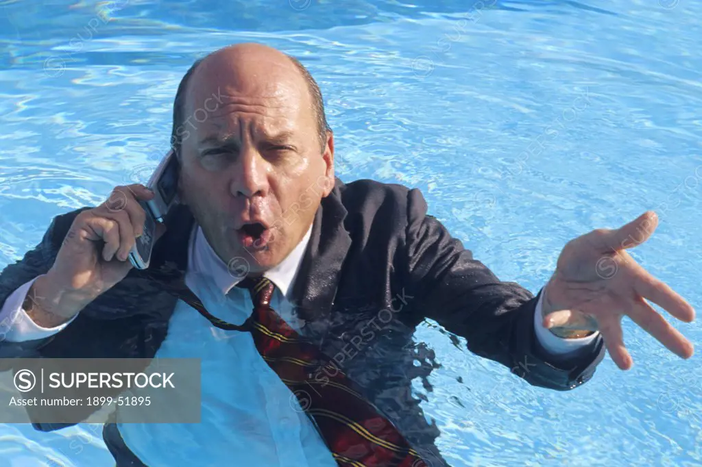 Businessman On Cellular Phone In Swimming Pool