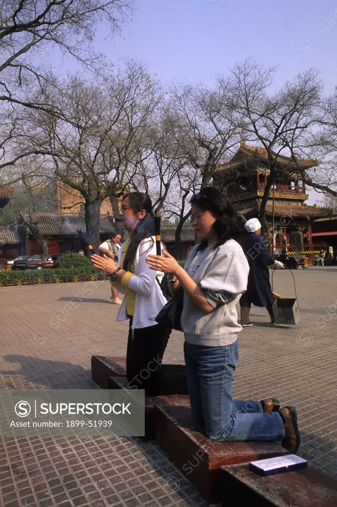 China, Beijing. Women Worshipping And Burning Incense At Lama Temple