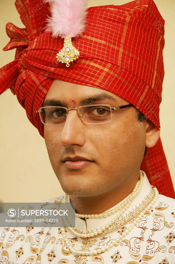 Indian Gujarati Bridegroom Wearing Turban With Broach And An Embroidered Coat Called 'Sherwani' And Necklace Of Pearls On His Wedding Day, India