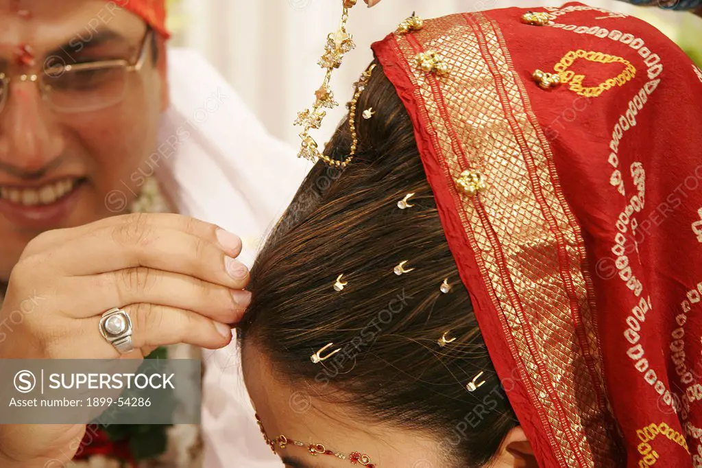 Indian Gujarati Bridegroom Putting Red Powder Called 'Sindoor' On The Bride'S Forehead As Ritual Of Indian Wedding And Sign Of Marriage.