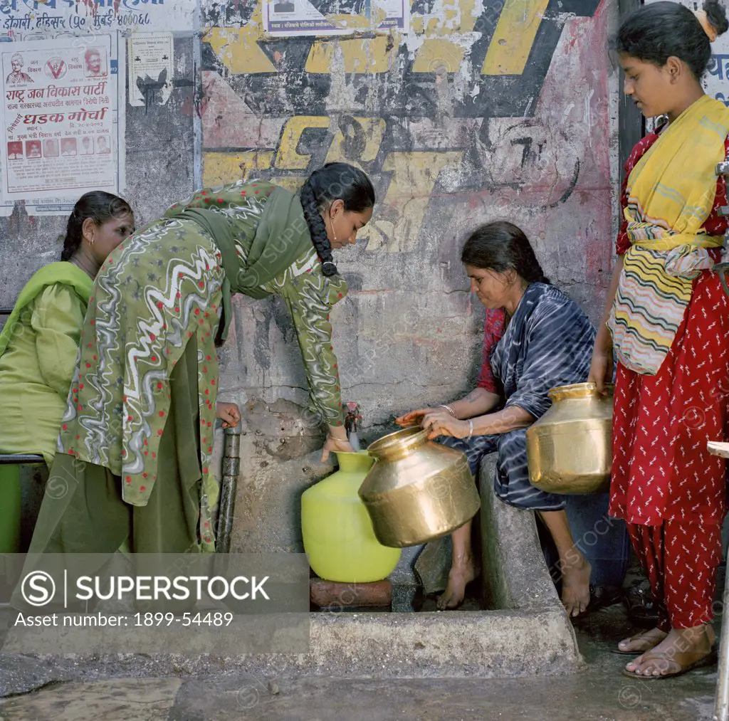 Women In A Slum Collecting Water From A Community Tap. Mumbai, India