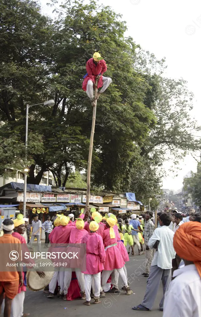 Adivasi From Mokhada Performing Acrobatics On The Beats Of The Drum During The Religious Procession At Court Naka, Thane, Maharashtra, India,