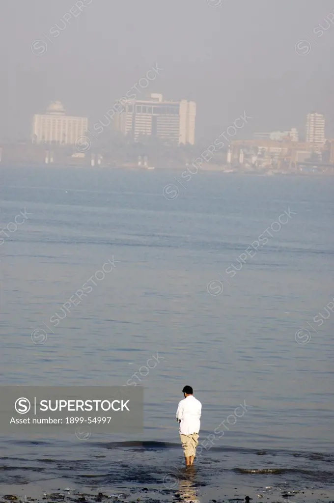Man Performing Morning Pooja At The Sea Shore, India