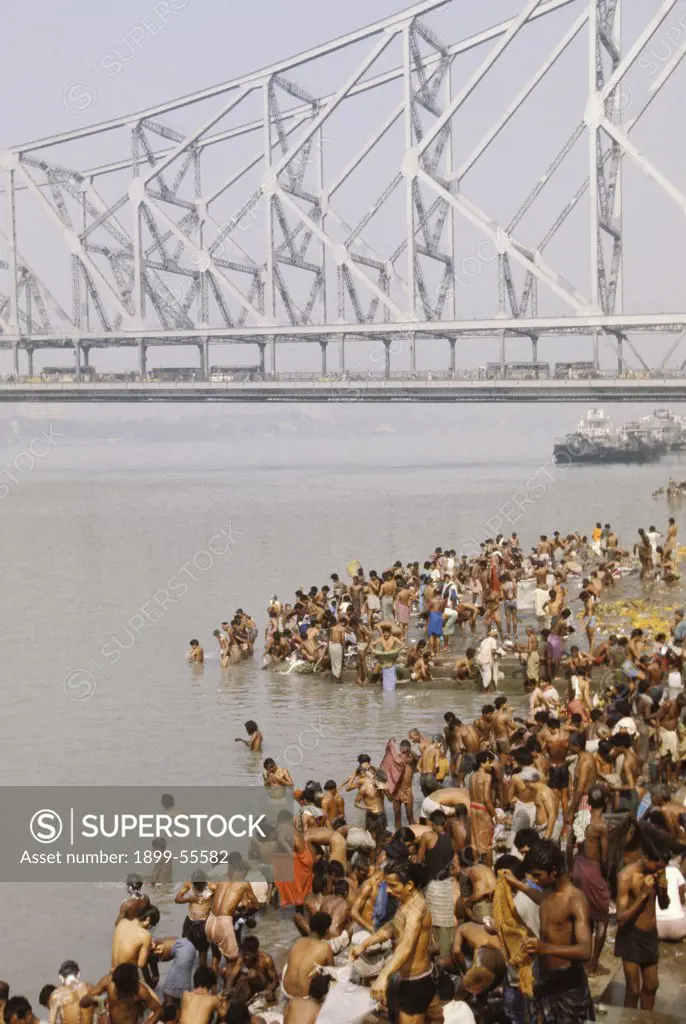 India, West Bengal, Calcutta. People Bathing Near Howrah Bridge. (450-Meter Cantilevered Bridge)