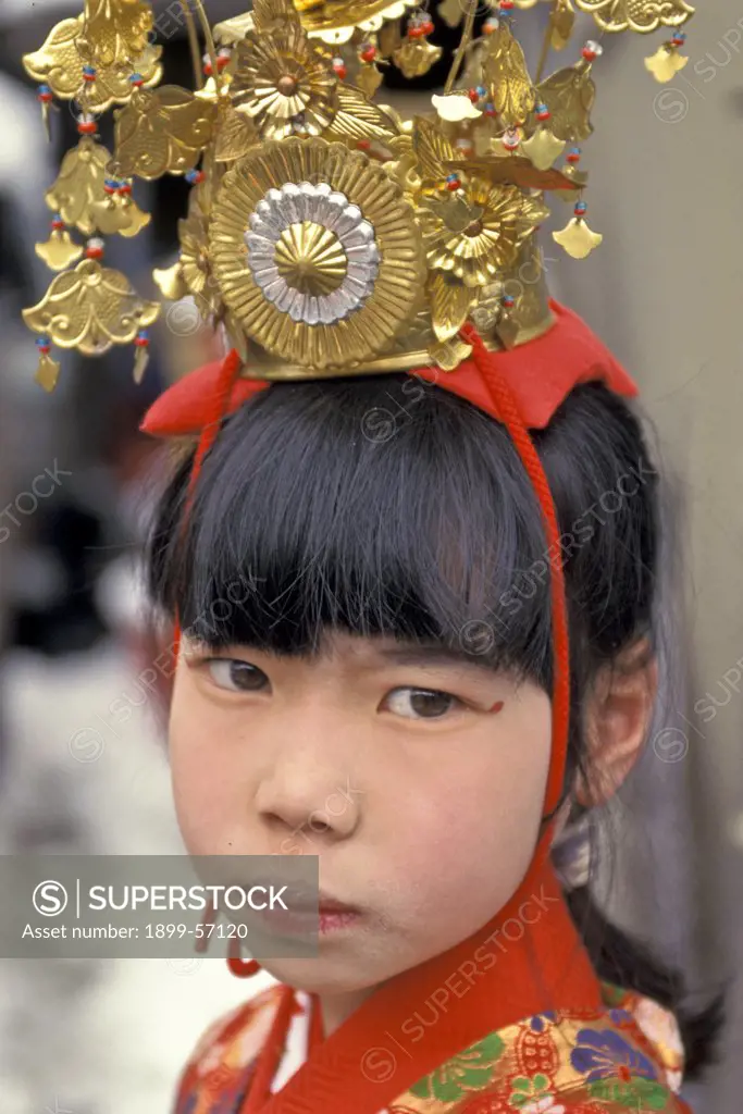 Japan, Takayama. Girl Wearing Ornate Hat At Festival.