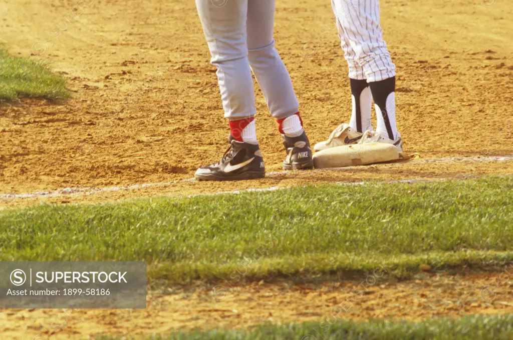 High School Baseball Game . Legs And Feet Of Runner On Base, And Baseman