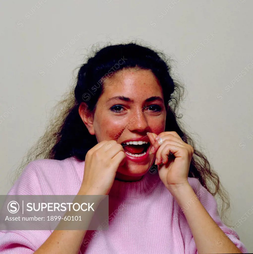 Teenage Girl Flossing Her Teeth