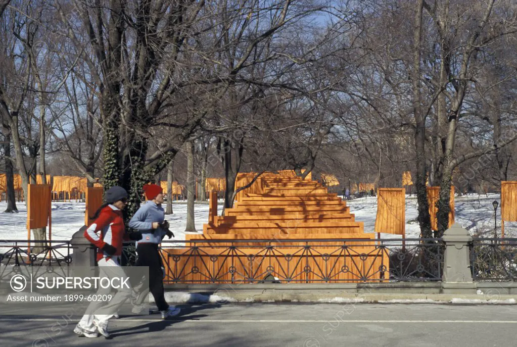 New York. New York City. Central Park. The Gates - Christo. East Side Drive Runners Crossing Bridge Over Path.