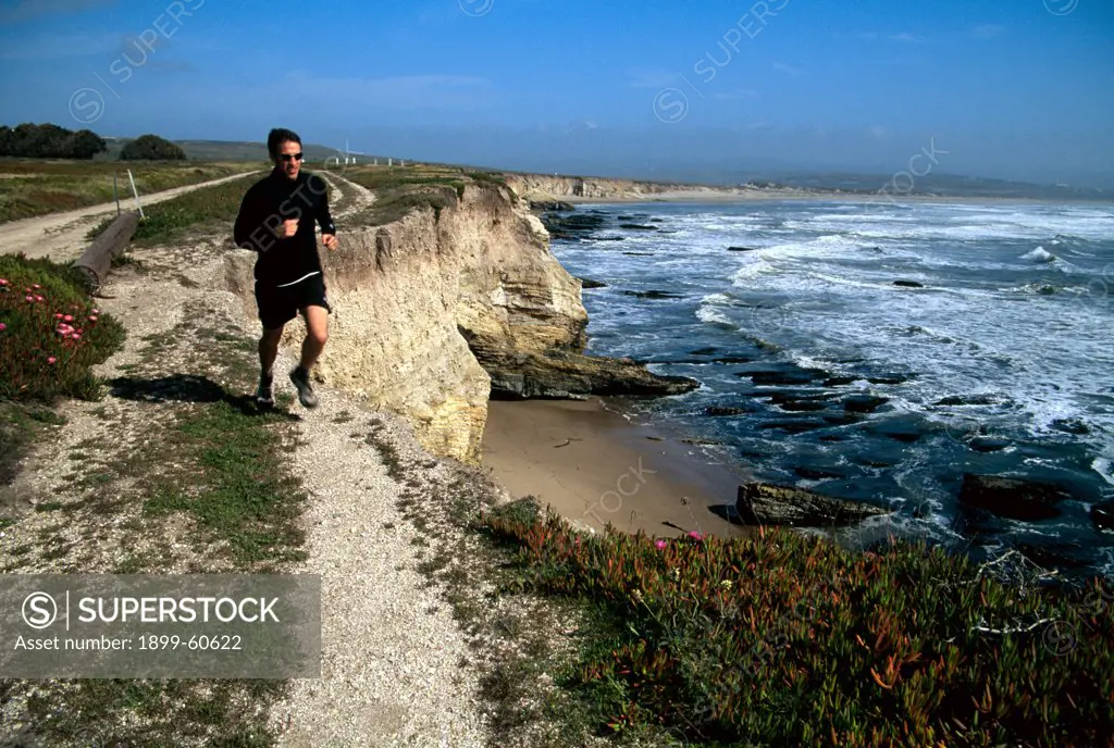 Man Running On Coastal Road In California
