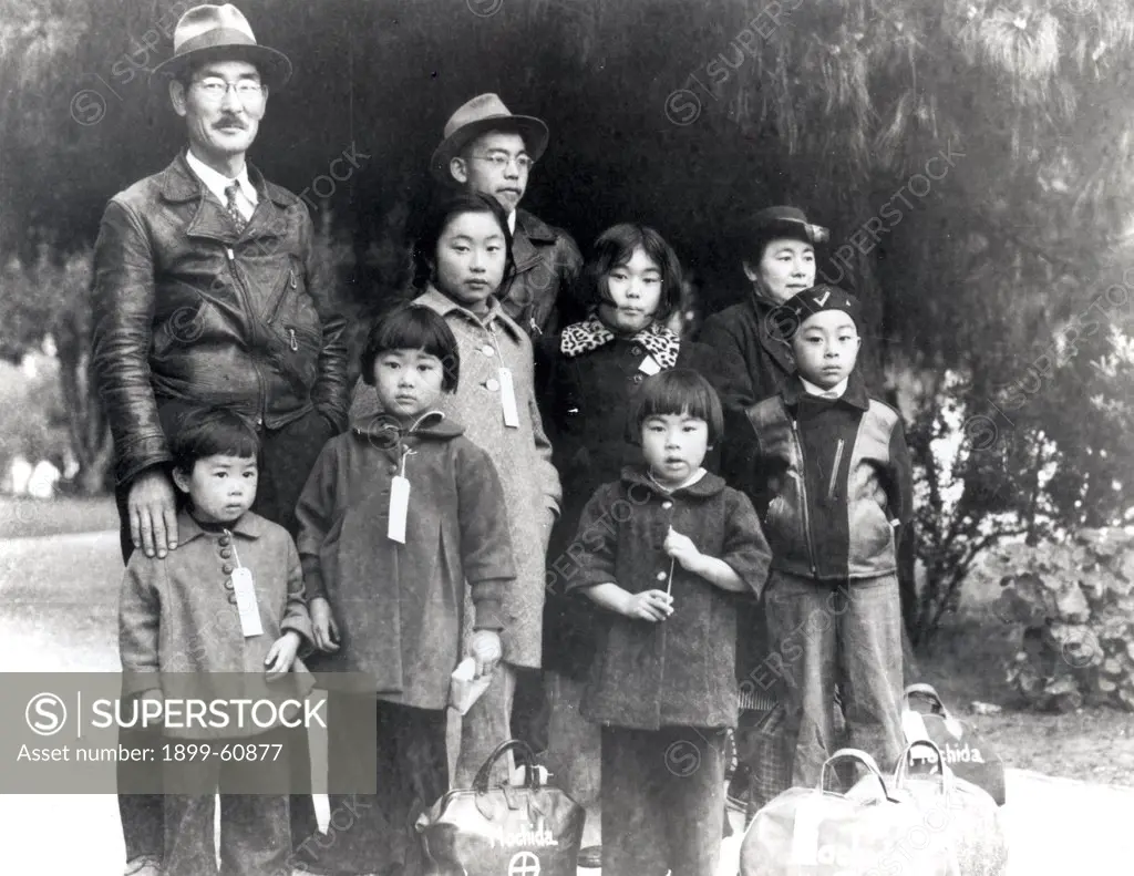 Hayward, California. Members Of The Mochida Family Awaiting Evacuation Bus. Identification Tags Are Used To Aid In Keeping The Family Unit Intact During All Phases Of Evacuation. Mochida Operated A Nursery And Five Greenhouses On A Two-Acre Site In Eden T