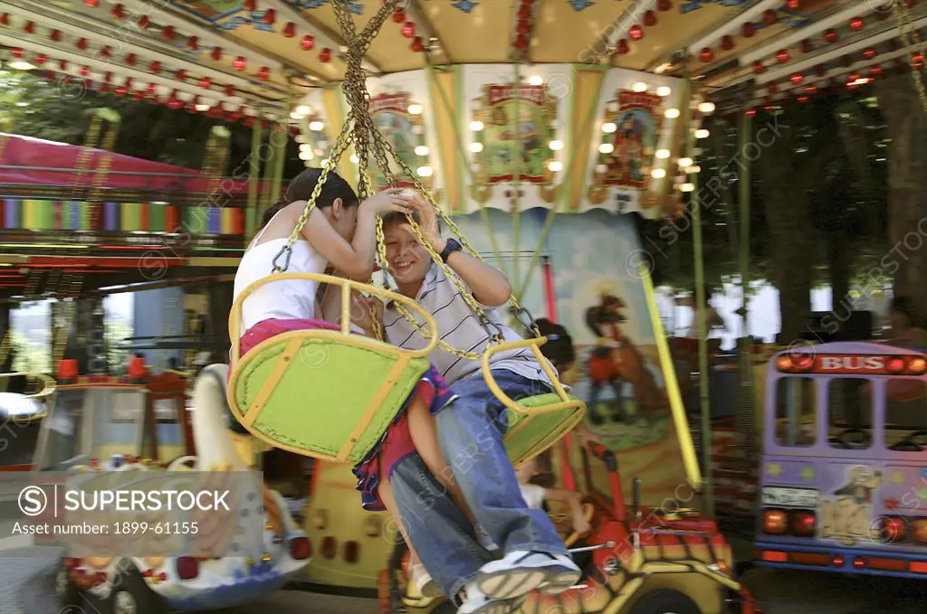 Girl And Boy On Carnival Carousel