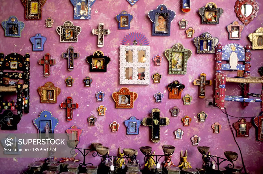 Mexico, San Miguel De Allende. Small Miniatures, Icons, Art Work, And Candleholders Placed On A Wall.