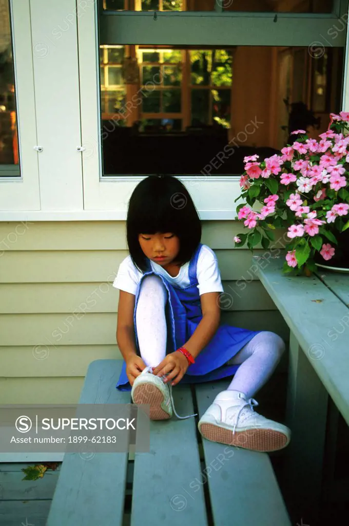 Young Girl Tying Her Shoe.