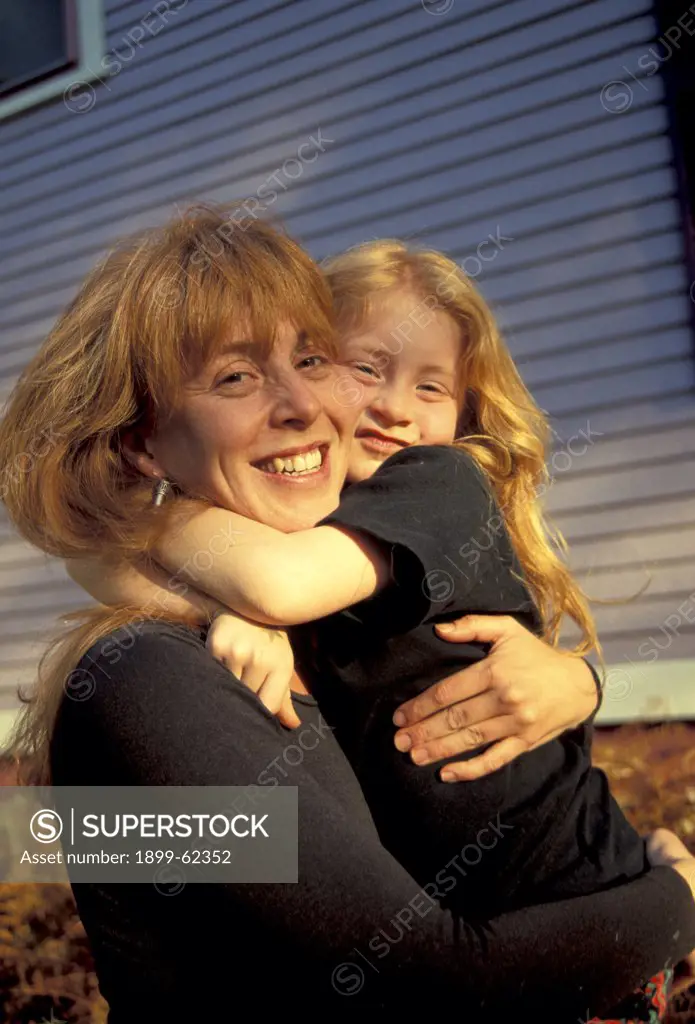Portrait Of Mother Hugging Daughter.
