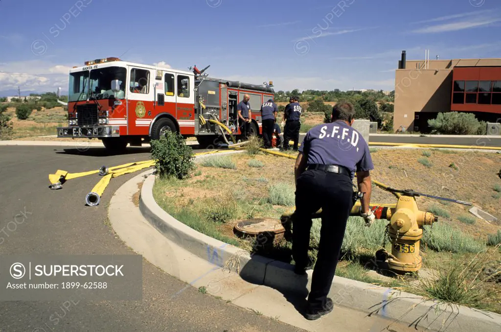 New Mexico. Santa Fe. Firetruck And Fireman At Hydrant - Testing Hoses
