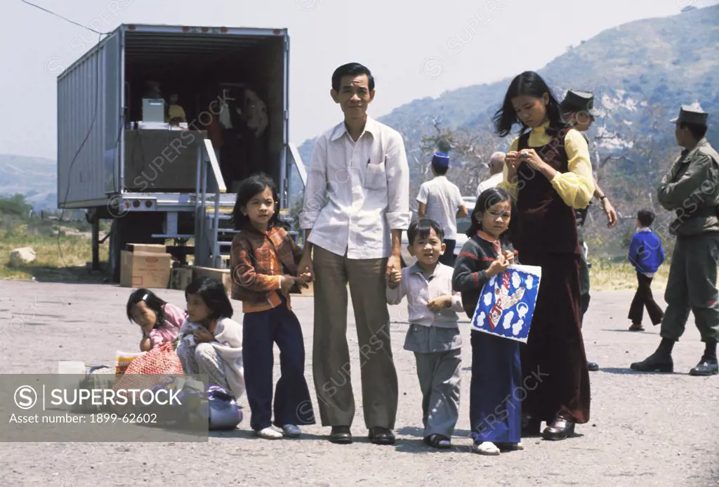 California. 1975 Vietnamese Refugee Family At Camp Pendleton.