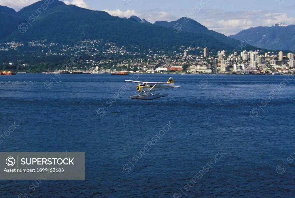Canada, British Columbia, Vancouver. Floatplane Landing In The Bay.
