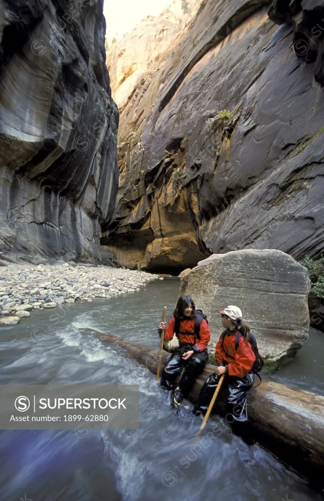 Utah. Zion National Park. The Narrows. Mother And Daughter Resting On Log