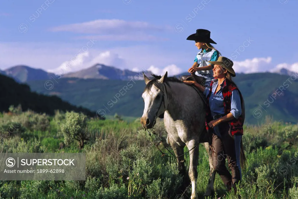 Colorado, Crested Butte. Woman And Young Girl Horseback Riding