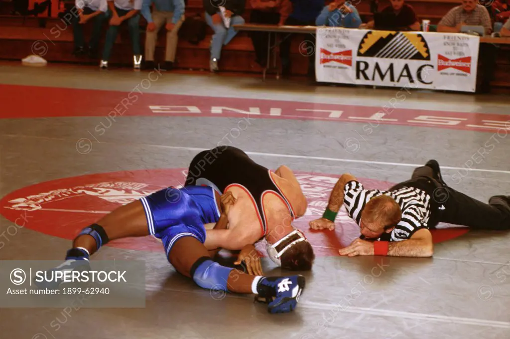 Colorado, Gunnison. Referee Looks At Two Students Wrestling. Western State College.