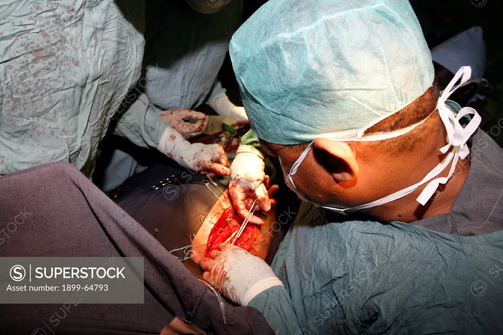 Surgeons stitching surgical wound