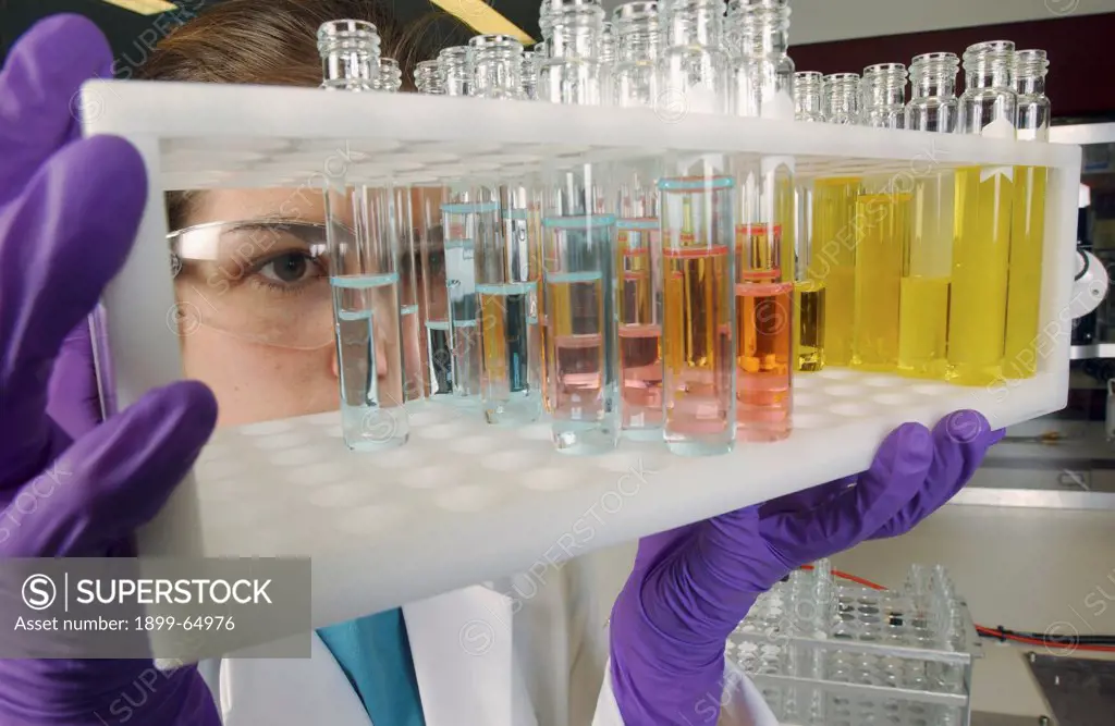 Laboratory assistant analyzing test tube samples