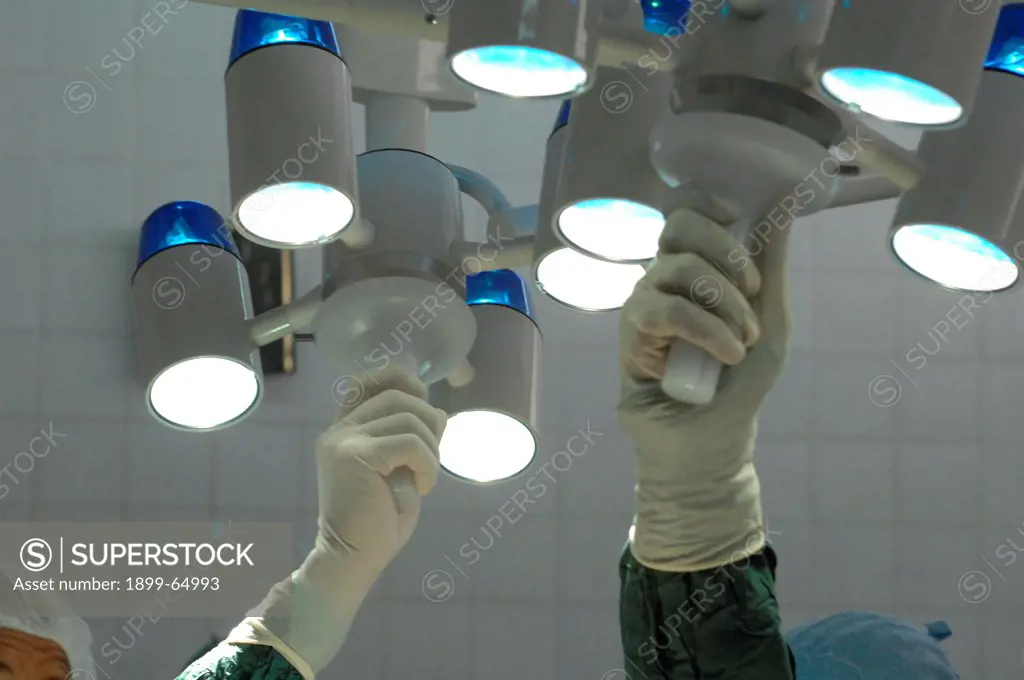 Surgeon adjusting operating theatre lighting