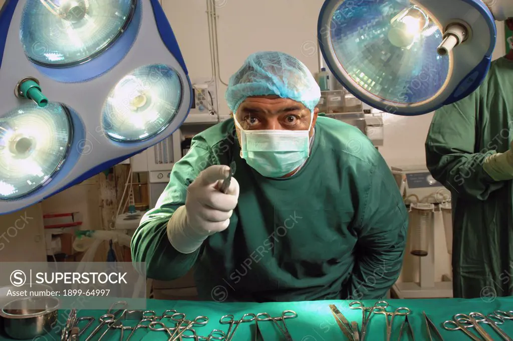 Surgeon holding scalpel towards camera