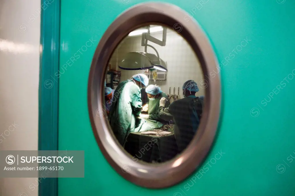 View through operating door window of surgical staff