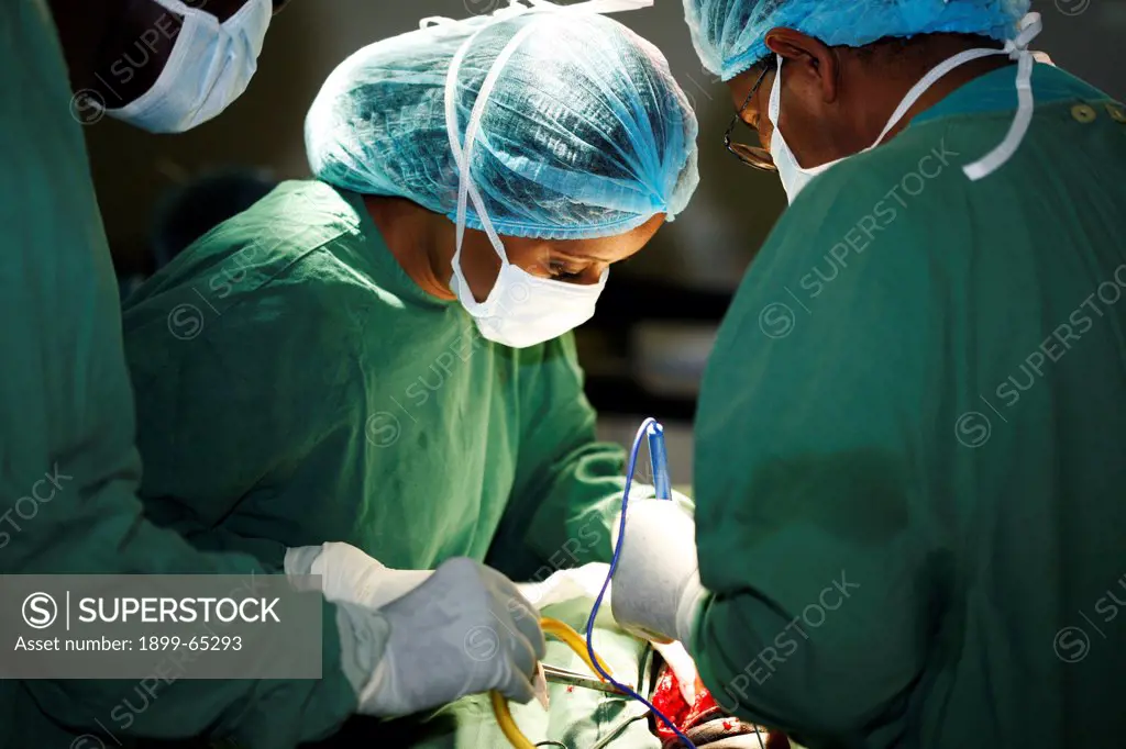 Female surgeon and her assistants operating on patient.
