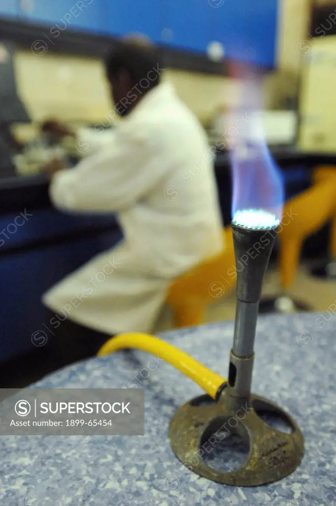 Lit bunsen burner on laboratory table,
