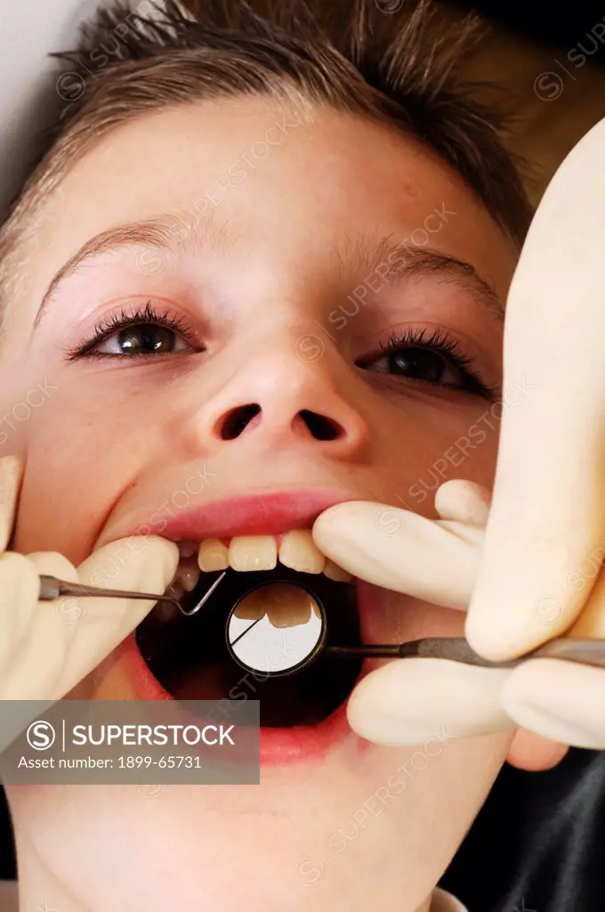 Dentist inspecting boys mouth before treatment
