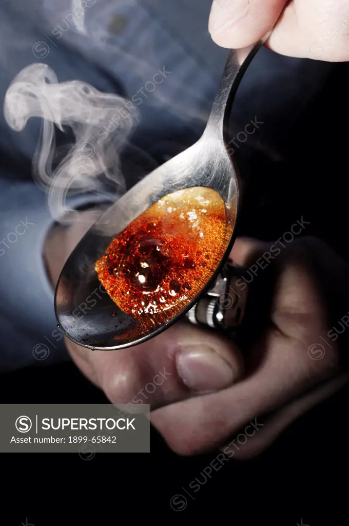 Re-enactment of heroin user burning heroin on spoon