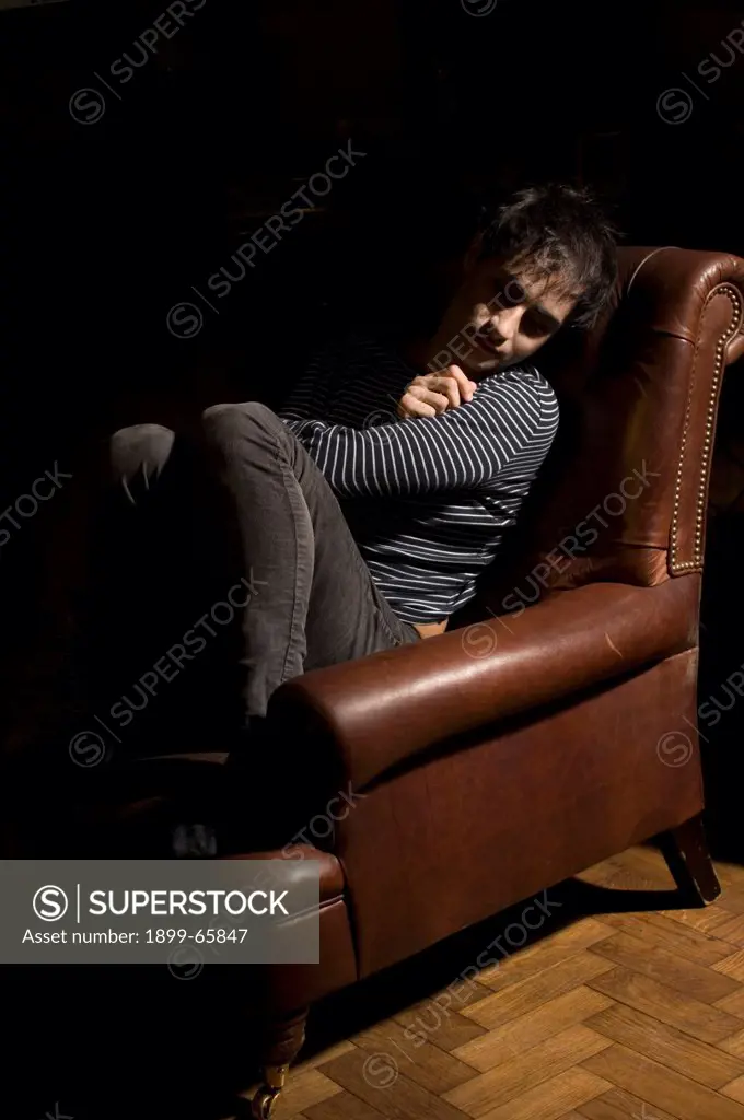 Man suffering from depression sitting in armchair