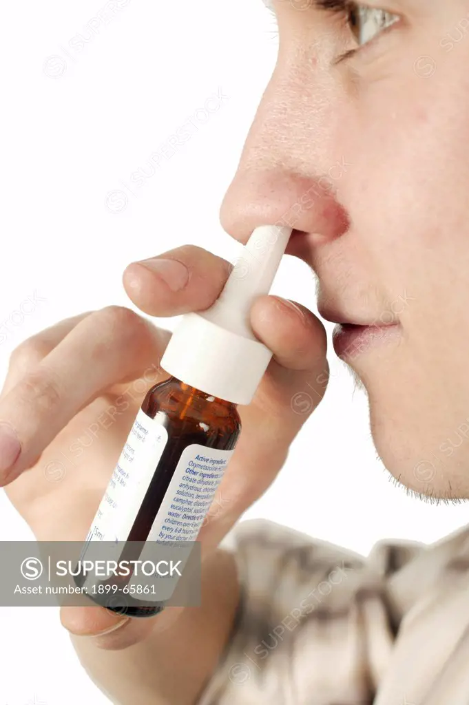 Young man using nasal spray