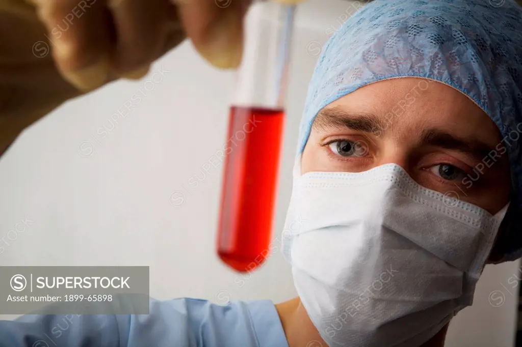 Laboratory technician examining liquid contents of test tube