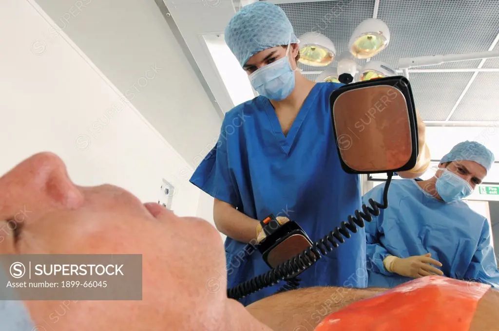 Doctors using defibrillator to resuscitate male heart