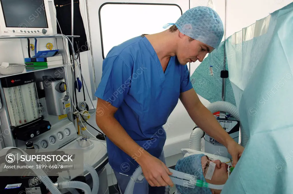 Anesthetist checking tubes connecting patient to anesthesia
