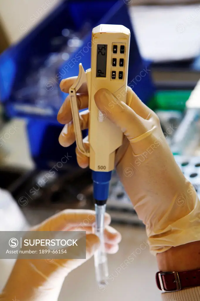 Pathologist using electronic pipette to collect accurate