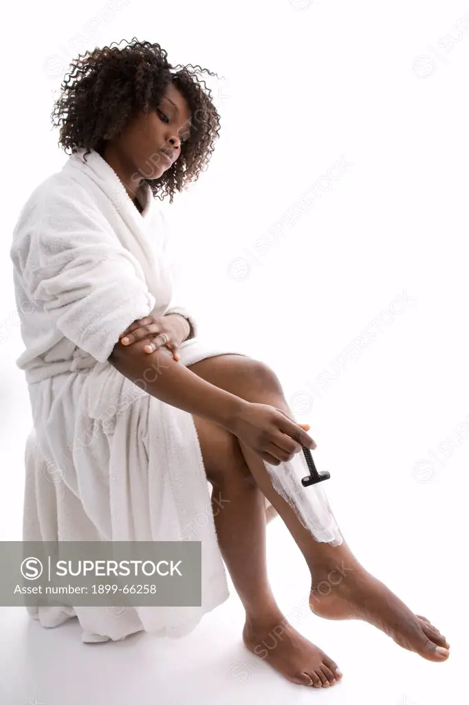 Young woman shaving her leg