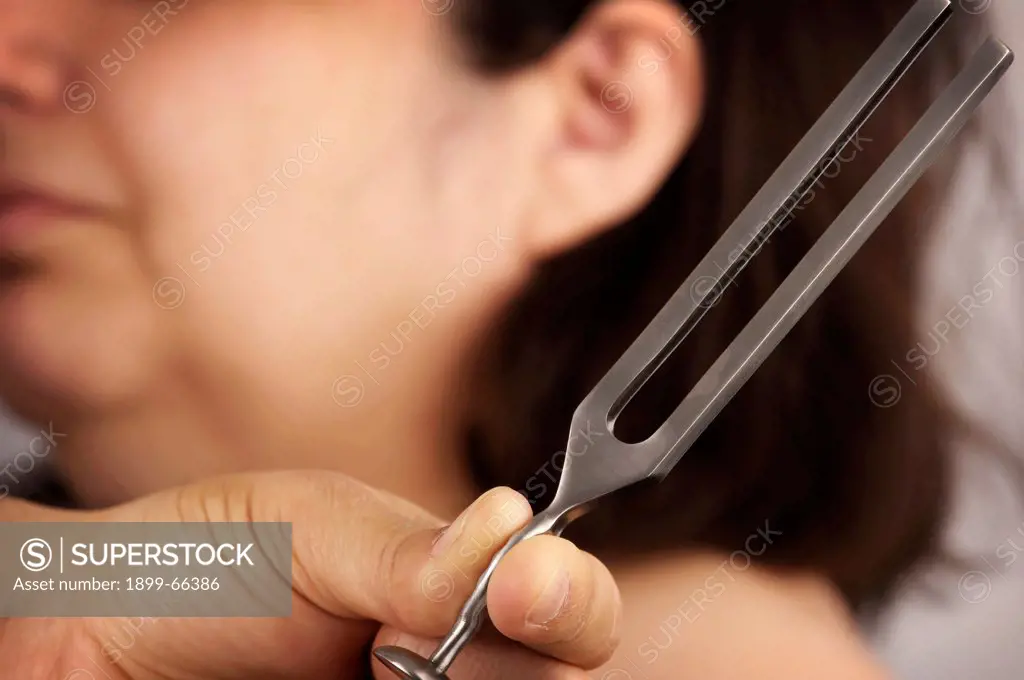 Doctor testing patients hearing using tuning fork