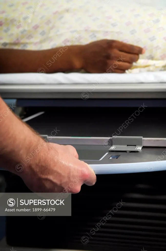 Close-up of hands of radiologist setting up x-ray machine