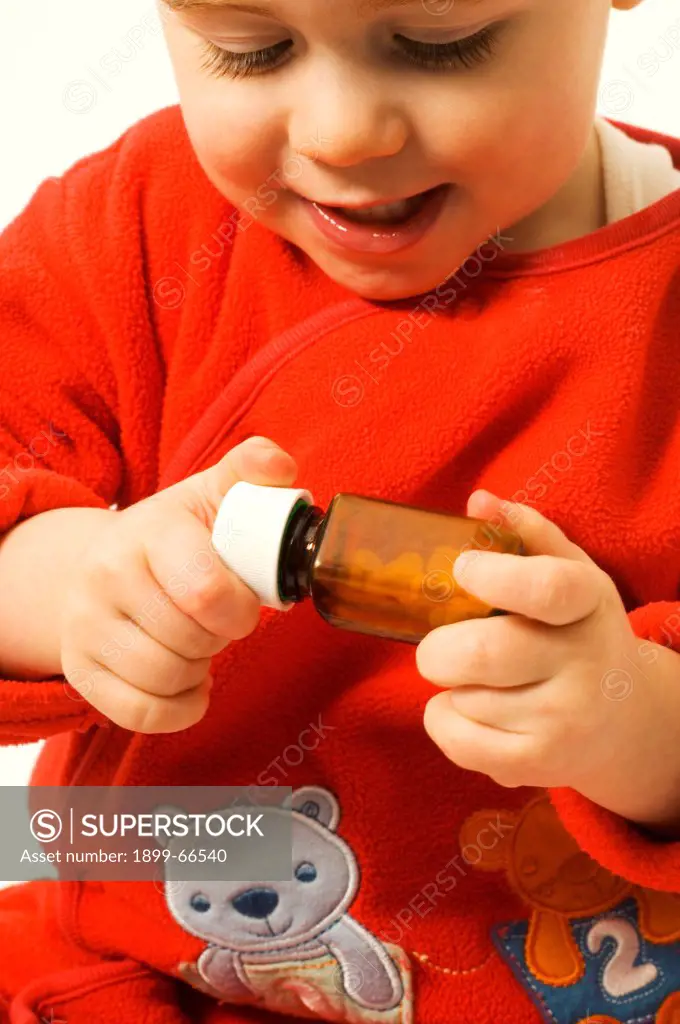 Close-up of baby boy trying to open medicine bottle
